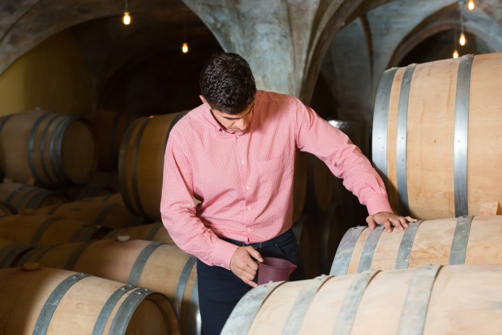 a man sitting in front of a barrel